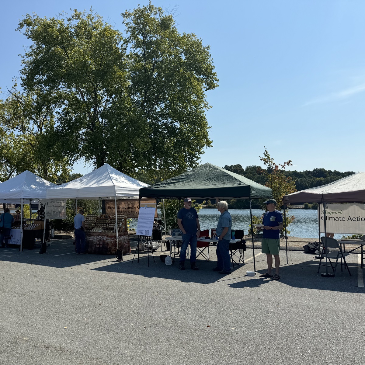 People talking by a Maynard farmers market stand about Climate Action